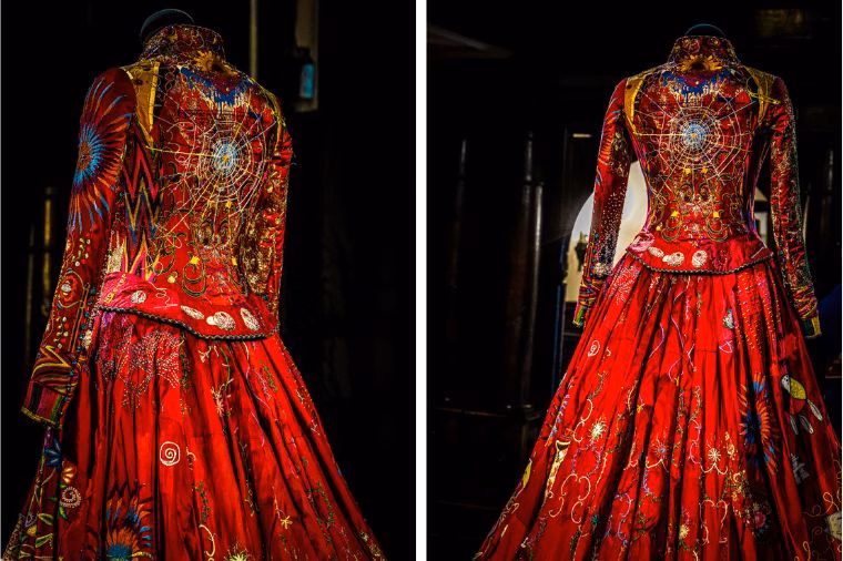 Back and side views of The Red Dress jacket from The Red Dress Project, displayed at Oakwell Hall for WOVEN in Kirklees. The embroidery features a radiant starburst and intricate gold-thread web design, emphasizing the storytelling and craftsmanship explored in this Red Dress Exhibition Review and The Red Dress Project Review.